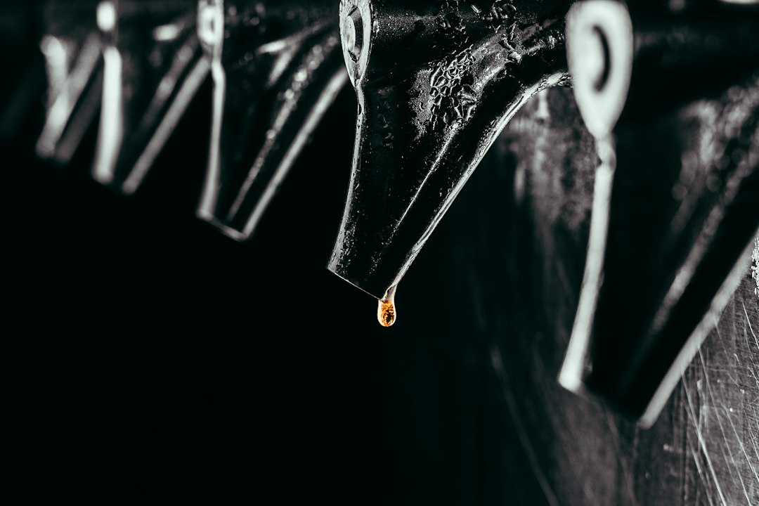 Close-up of beer taps at a brewery bar with a single drop of amber beer