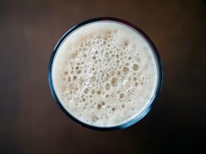 Tan foam on top of a glass of stout, seen from above