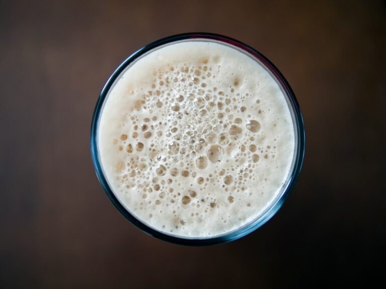 Tan foam on top of a glass of stout, seen from above